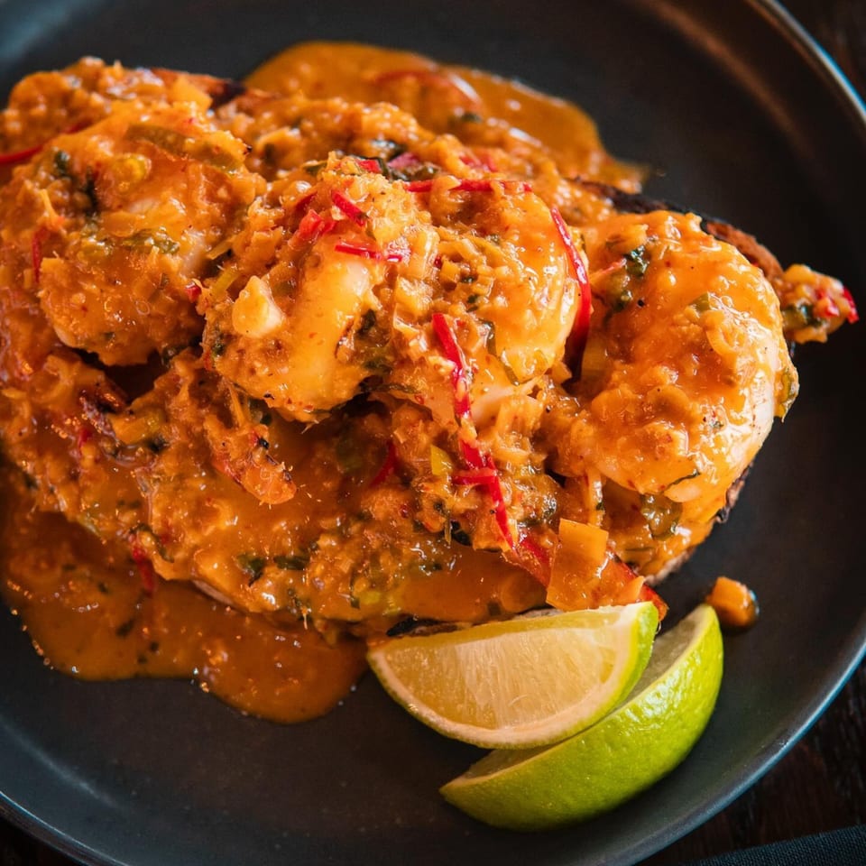 The Brookdale's shrimp dish, smothered in a rich orange sauce with red peppers and two lime wedges.